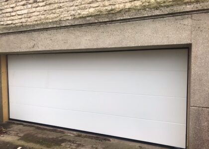 Porte de garage sectionnelle blanche sous un linteau.